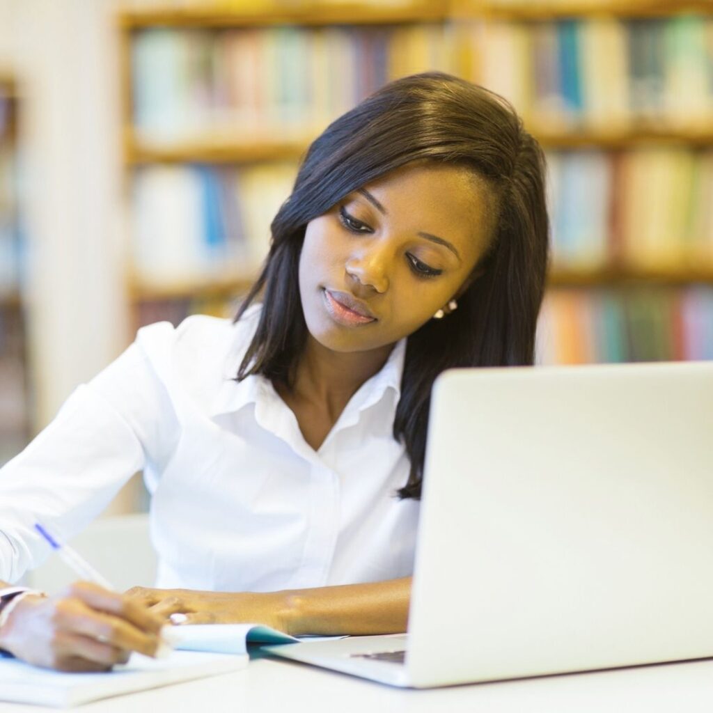 student in library with laptop